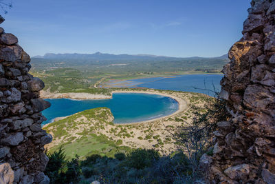 Scenic view of sea and rocky mountains against sky