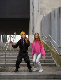 Full length of young woman using mobile phone