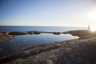 Man walking along rocky coastline