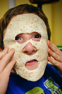 Portrait of boy playing with flat bread at home