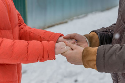 Midsection of couple holding hands