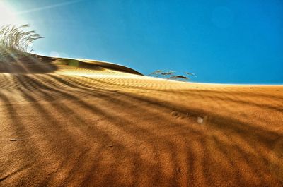 Scenic view of desert against clear blue sky