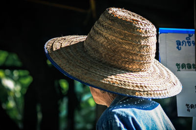 Rear view of man wearing hat on rock