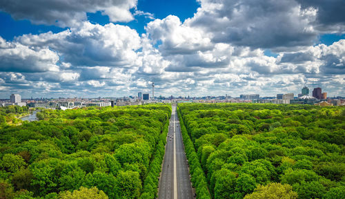 Panoramic shot of road amidst trees against sky in city