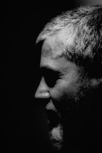 Close-up portrait of man over black background