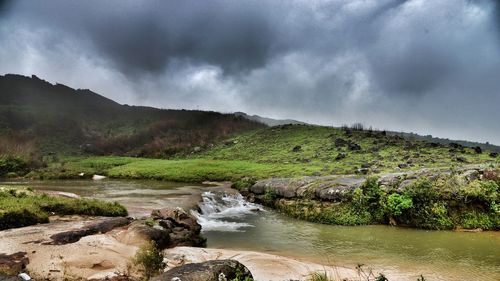 Scenic view of river amidst mountains against sky