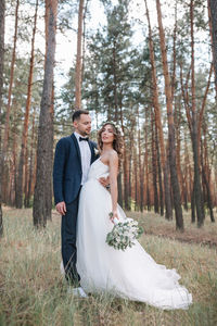 Newlywed young couple standing in forest