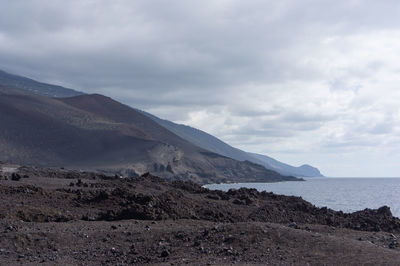 Scenic view of sea and mountains against sky