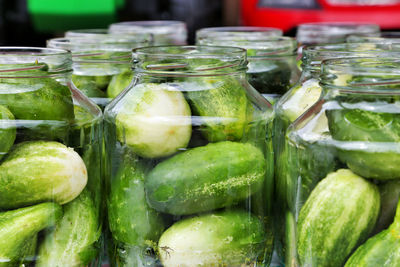 Close-up of cucumbers in jars for sale at market stall