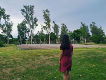 Rear view of woman standing on field