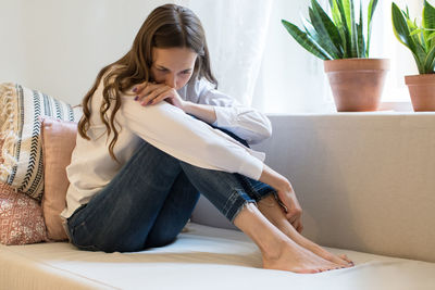 Crying young woman in depression, quarrelled with husband, holding smartphone and gets bad news. 