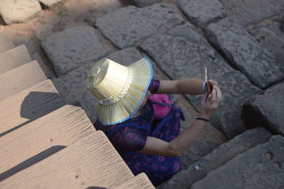 High angle view of woman sitting on rock