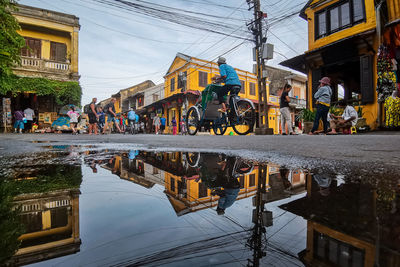 Close-up of puddle while people on street in city