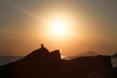 Silhouette of fishing at sunset