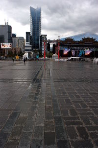 View of city street against cloudy sky