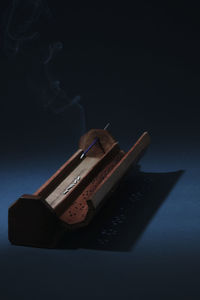 Close up of incense holder against black background