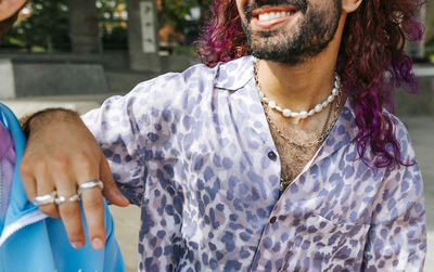 Smiling man with dyed hair wearing chains