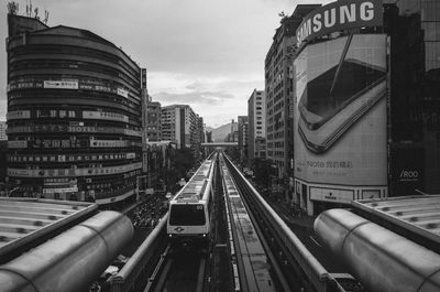 Railroad tracks in city against sky