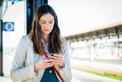 Portrait of young woman using mobile phone