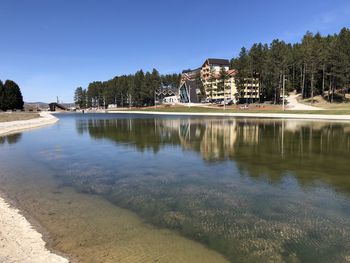 Scenic view of lake by buildings against clear sky