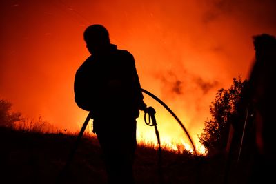 Silhouette man standing against orange sky