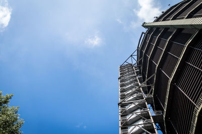 Low angle shot of industrial building against blue sky. gasometer, oberhausen, germany