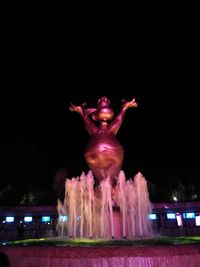 Low angle view of illuminated statue against sky at night