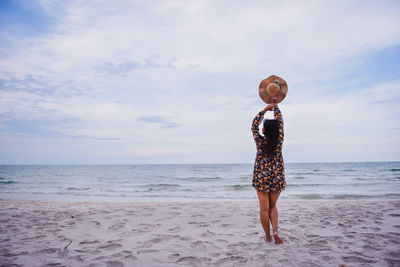 Full length of man standing on beach against sky