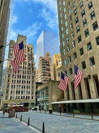 Low angle view of flags against buildings in city