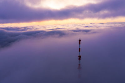 Communications tower rising above a sea of clouds at sunrise, salzburg, austria