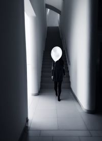 Full length of man standing in illuminated corridor