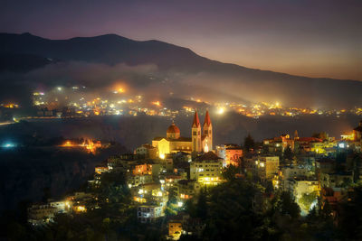 High angle view of illuminated buildings in city at night