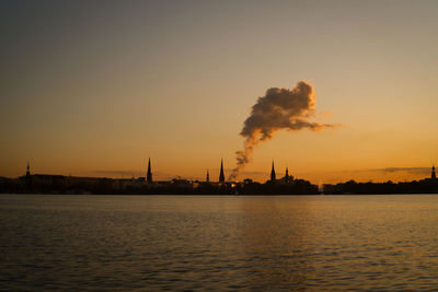 Smoke emitting from factory against sky during sunset