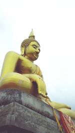 Low angle view of statue against temple building against sky