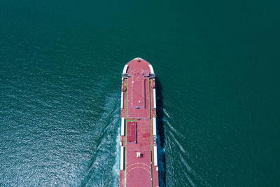 Aerial view ro-ro ship loading new cars. automotive container carriers sailing on the sea 