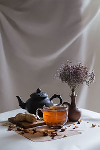 Herbal tea with nuts and spices on table