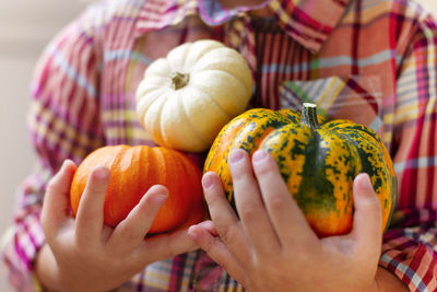 Midsection of girl holding pumpkins