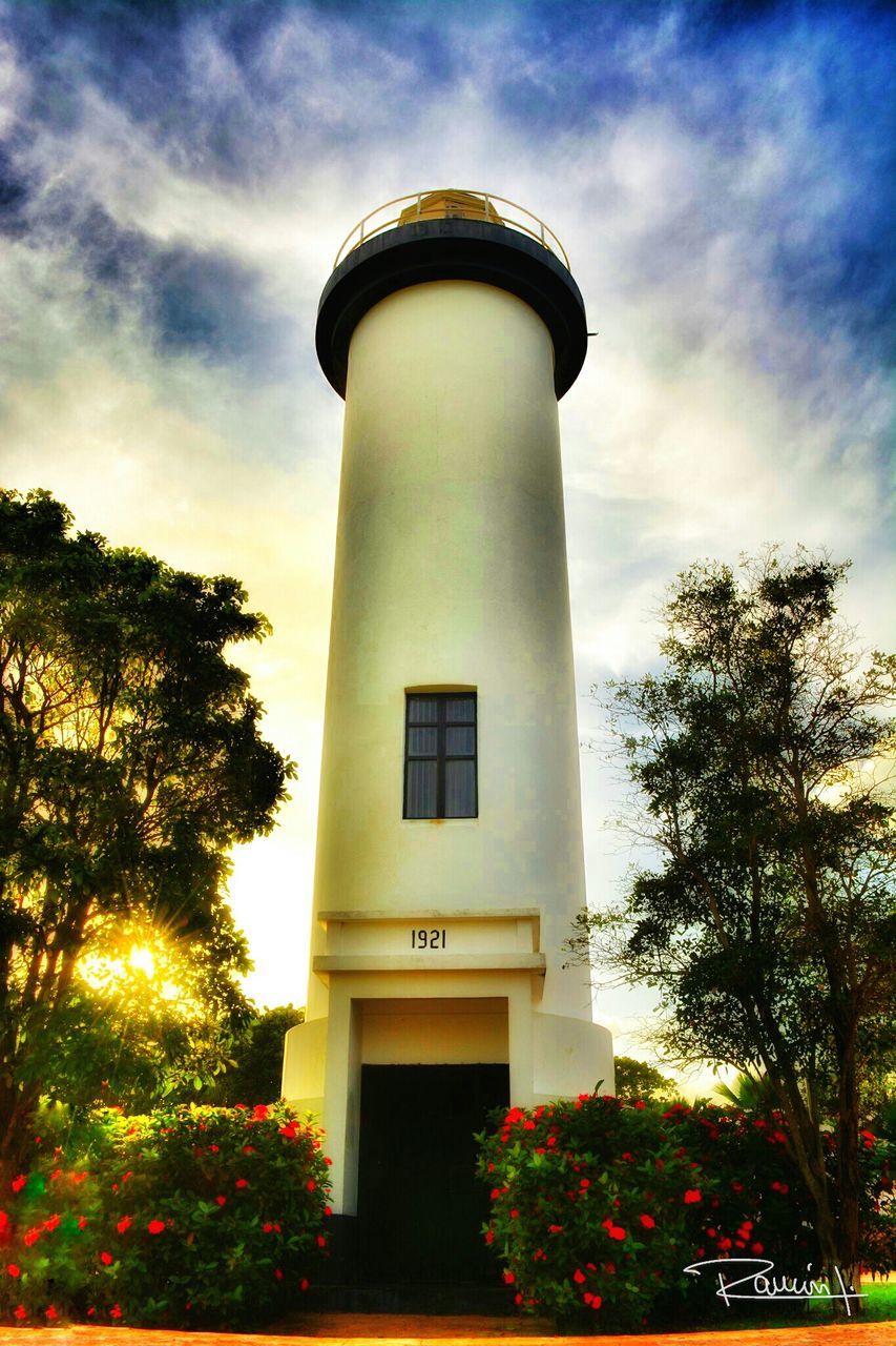 architecture, built structure, low angle view, building exterior, sky, tree, tower, cloud - sky, cloud, lighthouse, tall - high, growth, outdoors, day, no people, cloudy, nature, tall, guidance, direction