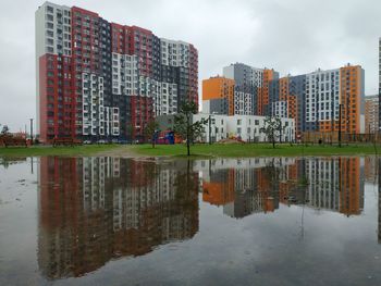 Reflection of buildings in lake against sky