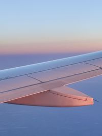 Cropped image of airplane wing against clear sky