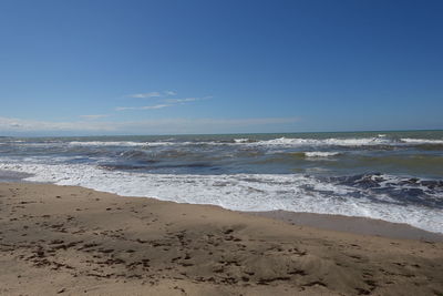 Scenic view of beach against clear blue sky