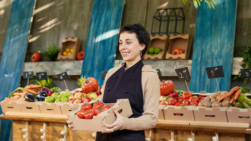 Portrait of woman holding food at market stall
