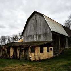 Built structure on field against cloudy sky