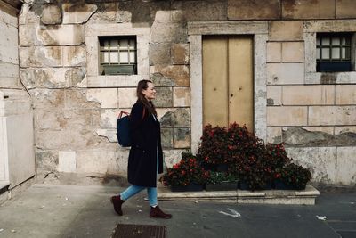 Woman standing by window of building