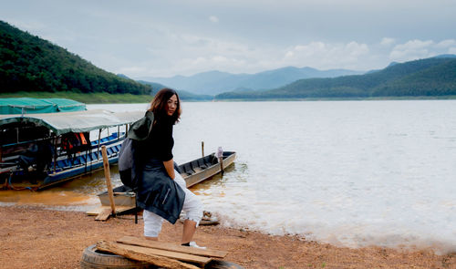 Man standing on shore against sky