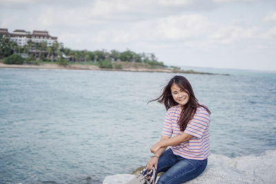 Full length of smiling young woman on beach