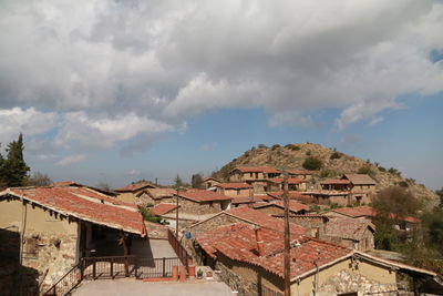 Houses in town against cloudy sky