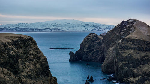 Scenic view of sea and mountains against sky