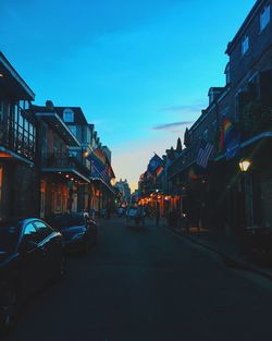 Cars on street in city against clear sky