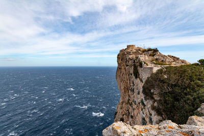 Rock formation in sea against sky